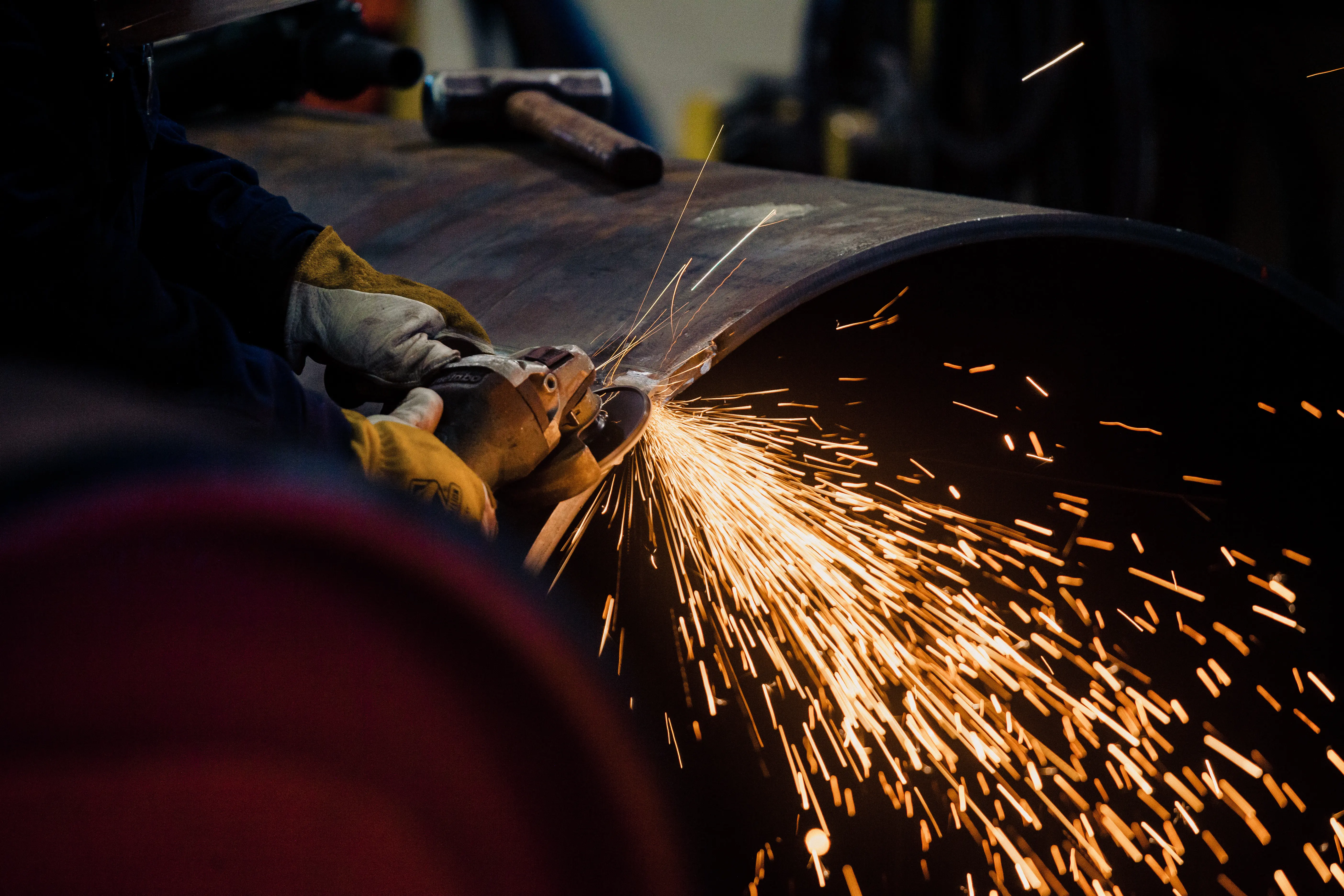 A man holding a welding machine working on steel structure